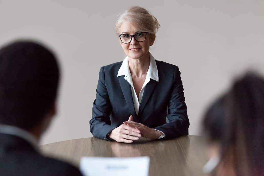 A senior HR recruiter interviewing candidates for a role.